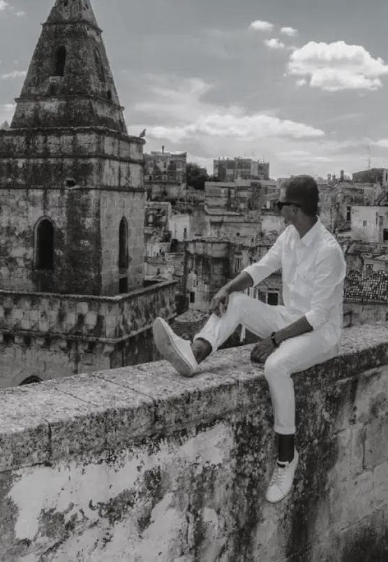 Mężczyzna siedzący na kamiennym murze