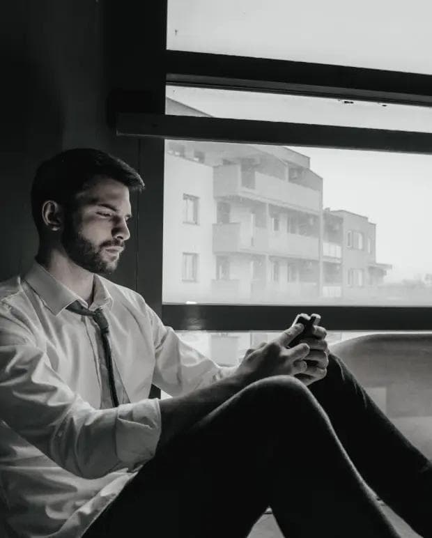 Zdołowany mężczyzna siedzący przy oknie